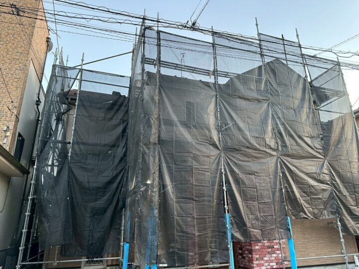 海老名市、屋根の重ね葺き(カバー工法)工事の施工中です。 足場の設置、足場にはメッシュシートを張り、粉塵や飛散物の飛び出しを防ぐための養生をします。 その後、棟板金や雪止めなどの金属部材を撤去し、屋根面を高圧洗浄します。