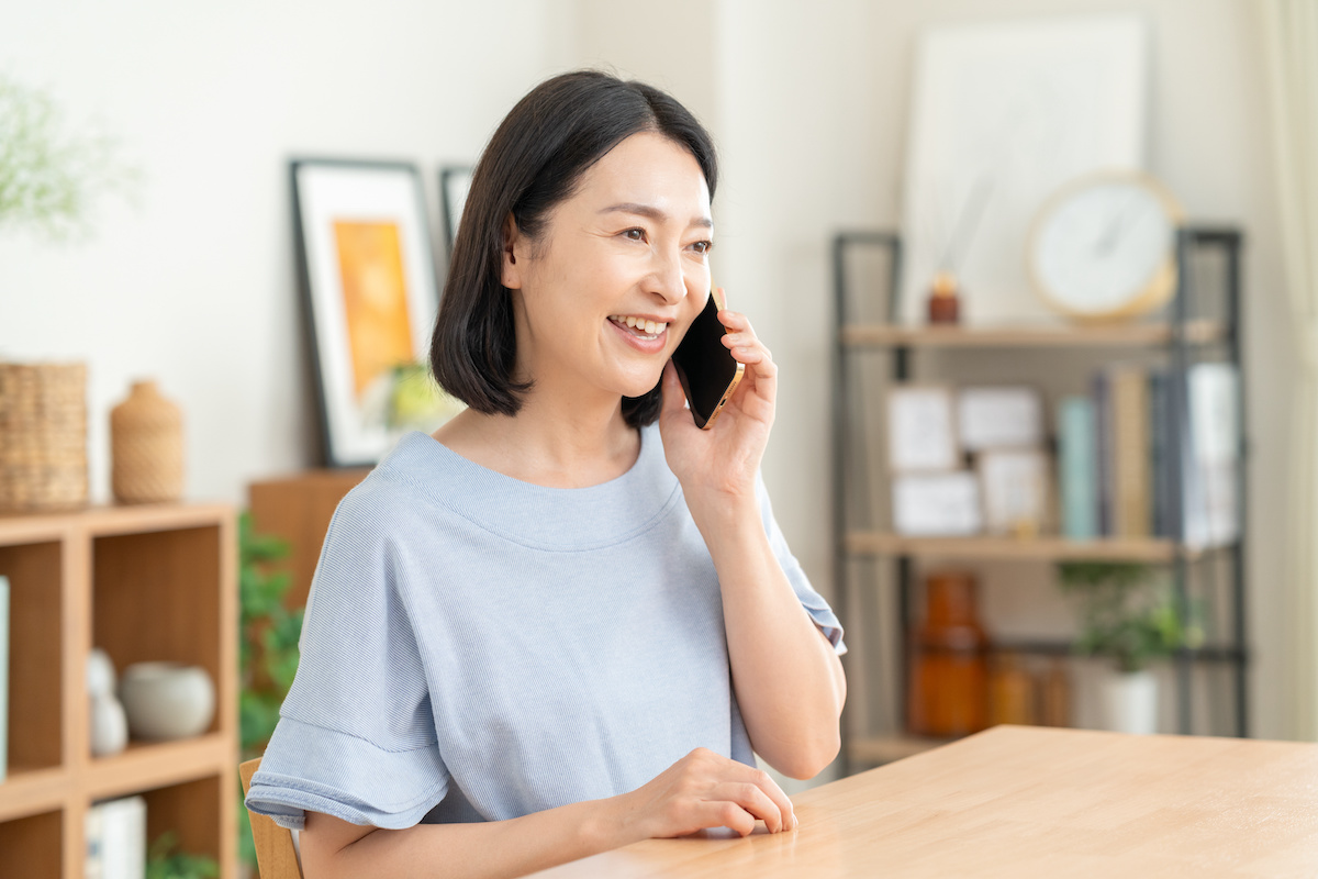 自宅から電話で住まいについて相談する女性