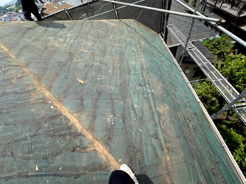 海老名市の戸建て住宅で、既存の屋根材を撤去した様子。屋根葺き替え工事の途中で、古い防水シートが露出している状態。