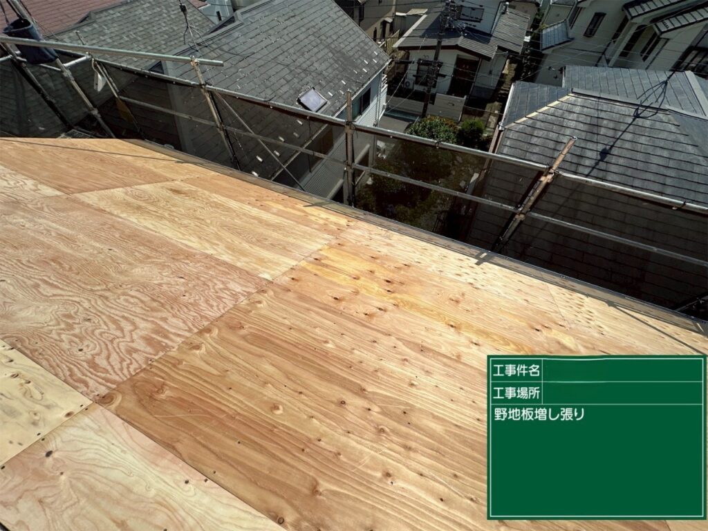 海老名市の戸建て住宅の屋根リフォームで、屋根下地に合板を増し張りした様子。野地板を屋根面に敷き、固定した施工工程。