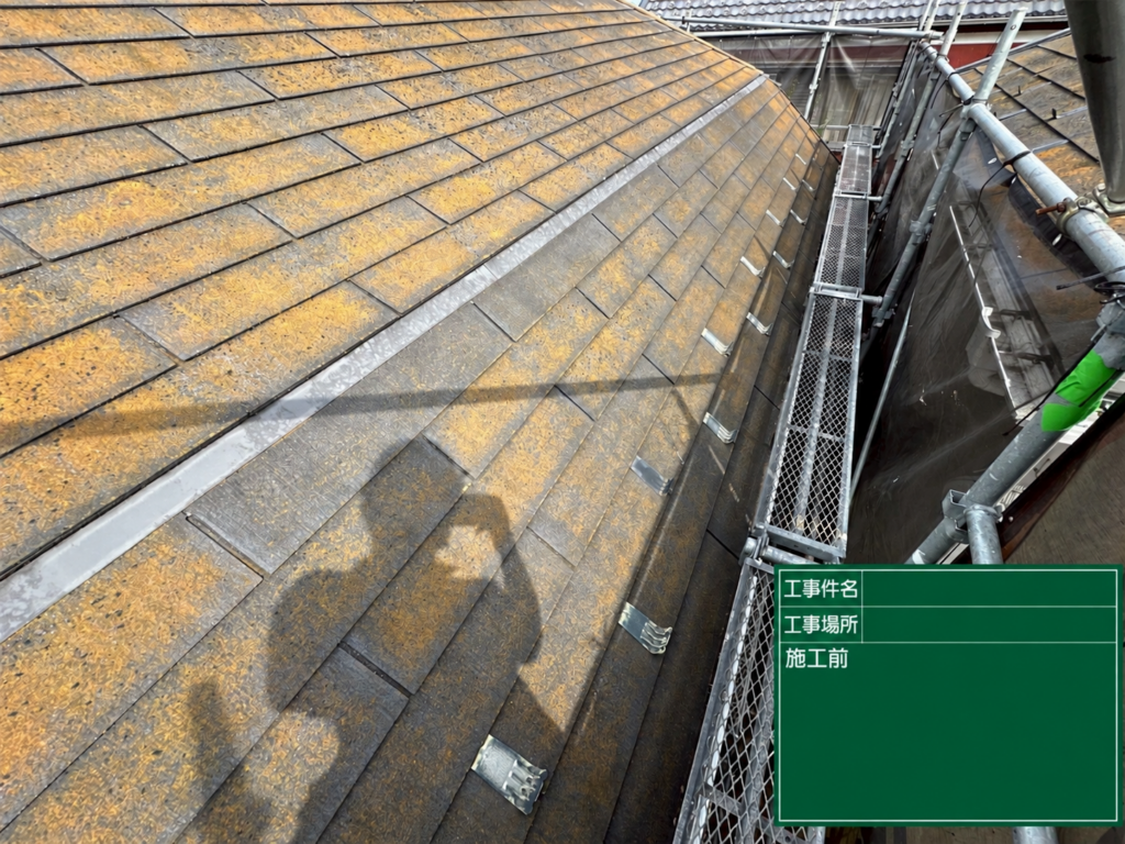 海老名市の戸建て住宅の屋根葺き替え工事前。スレート屋根の表面に色あせや黄褐色の付着物が見られる状態。